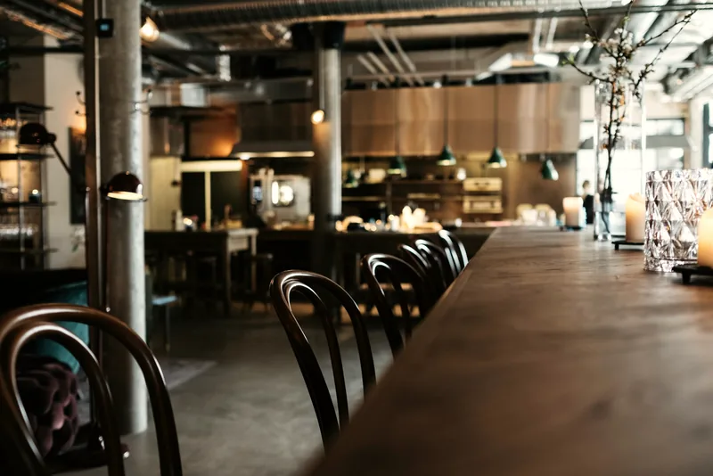 Mesa de madera de restaurante con sillas en luz cálida